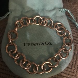 Round clasping link bracelet with heart lock.